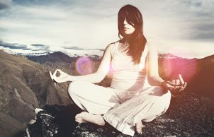 A woman meditating on mountains